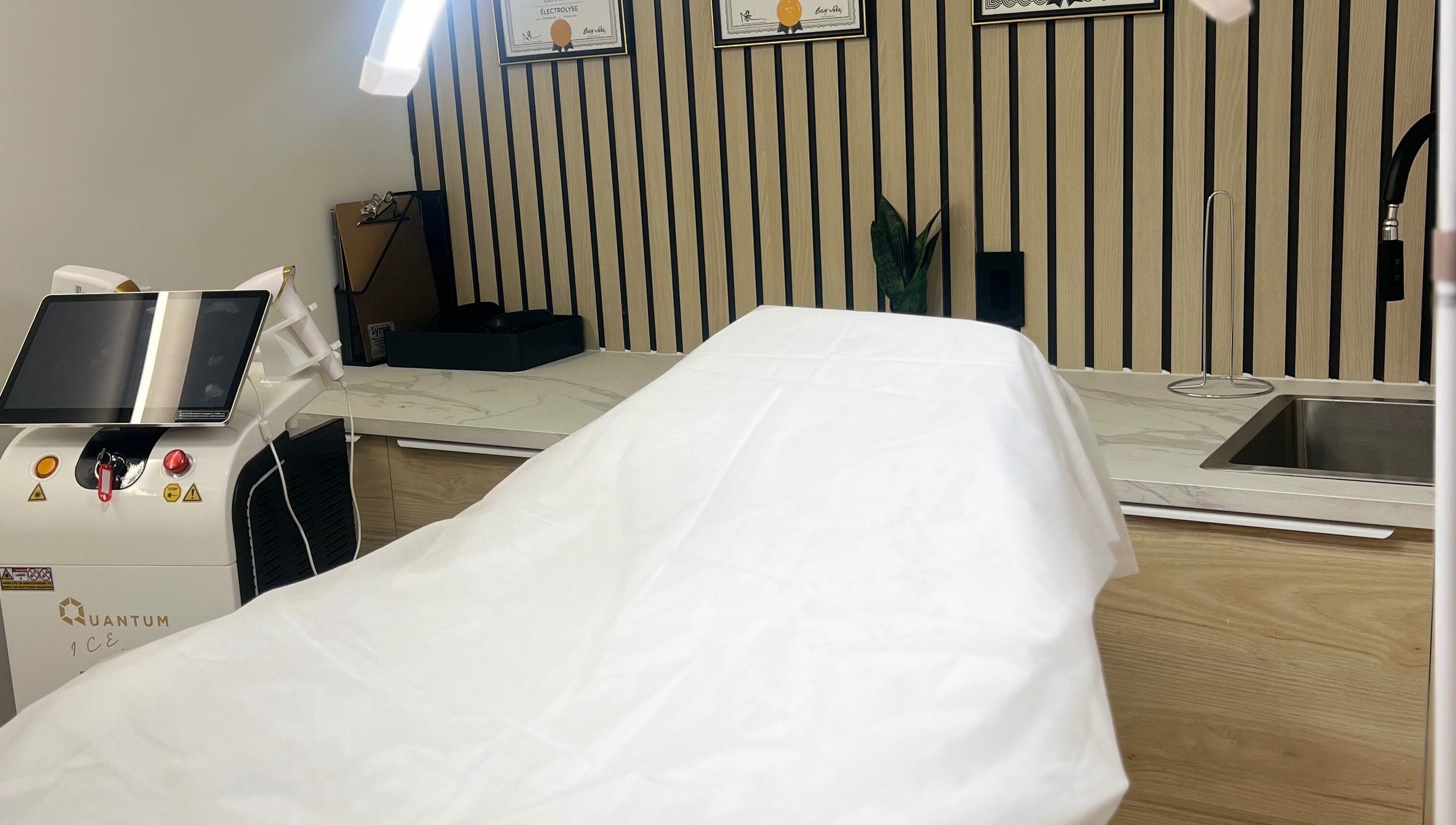 Salle de soins moderne à LEYZER SKIN, Longueuil, Québec, CA, avec équipement de pointe et ambiance apaisante.