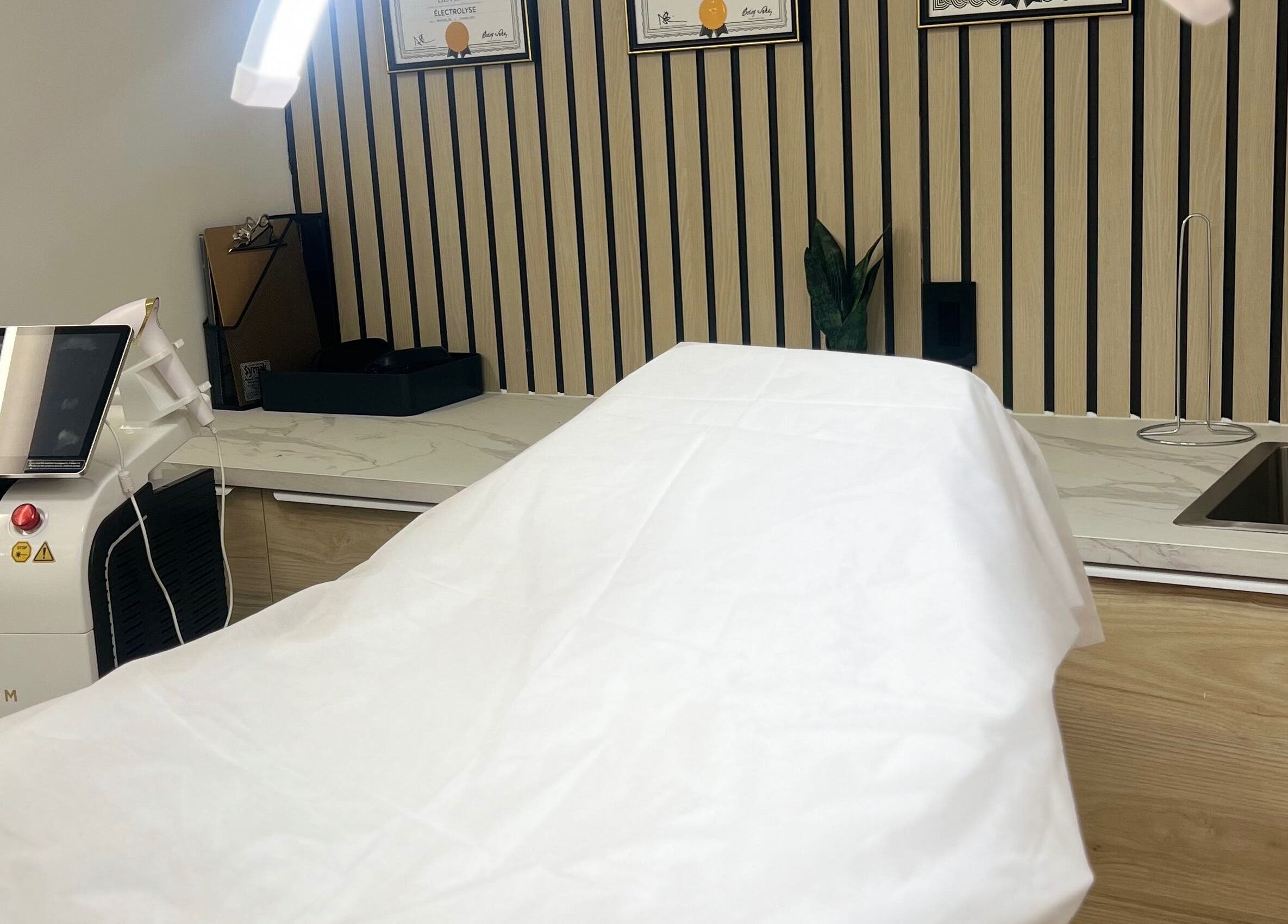 Salle de soins moderne à LEYZER SKIN, Longueuil, Québec, CA, avec équipement de pointe et ambiance apaisante.