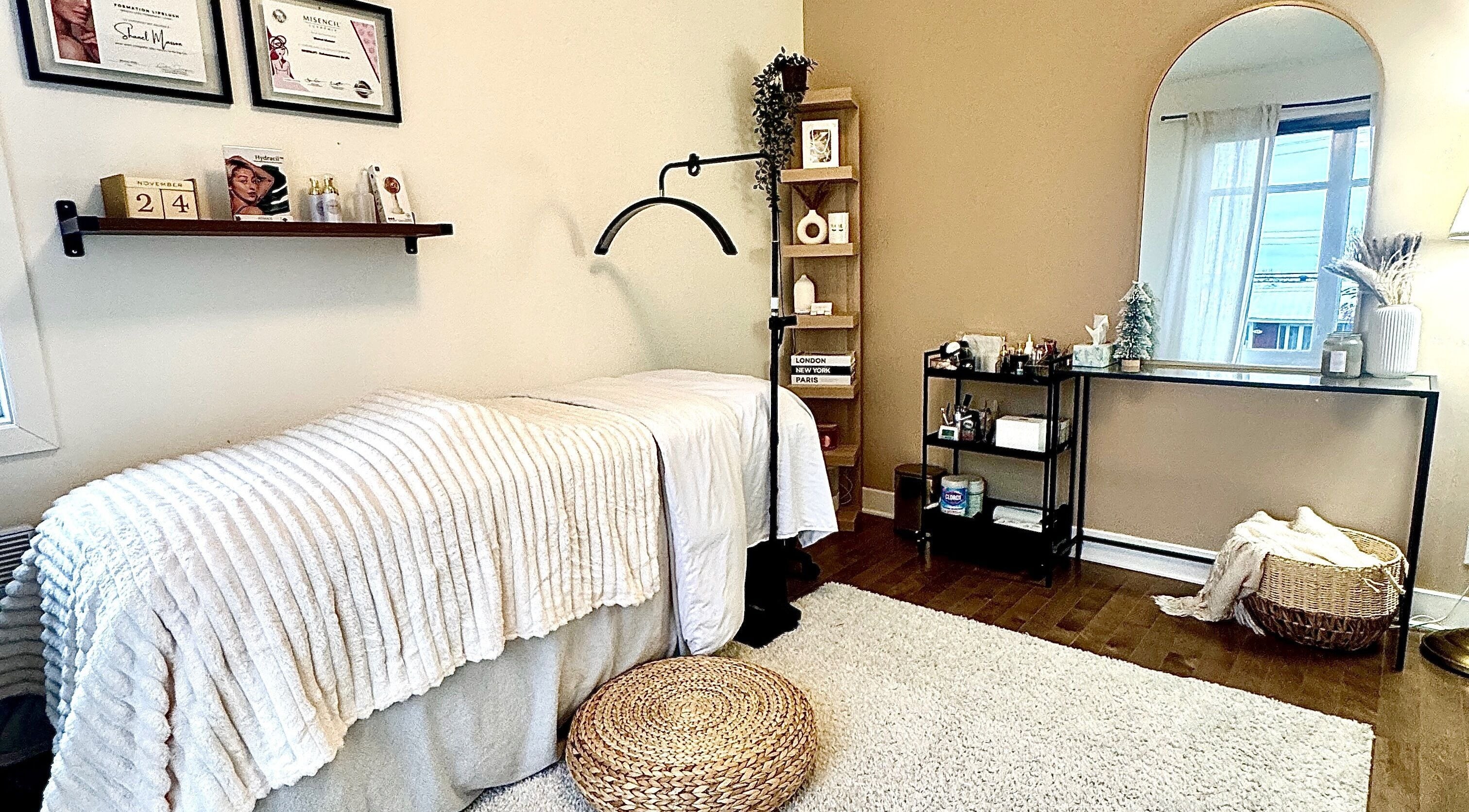 Salle de soins Esthetique Shanel à Saint-jean-sur-richelieu, Québec, CA avec table de massage et miroir élégant.