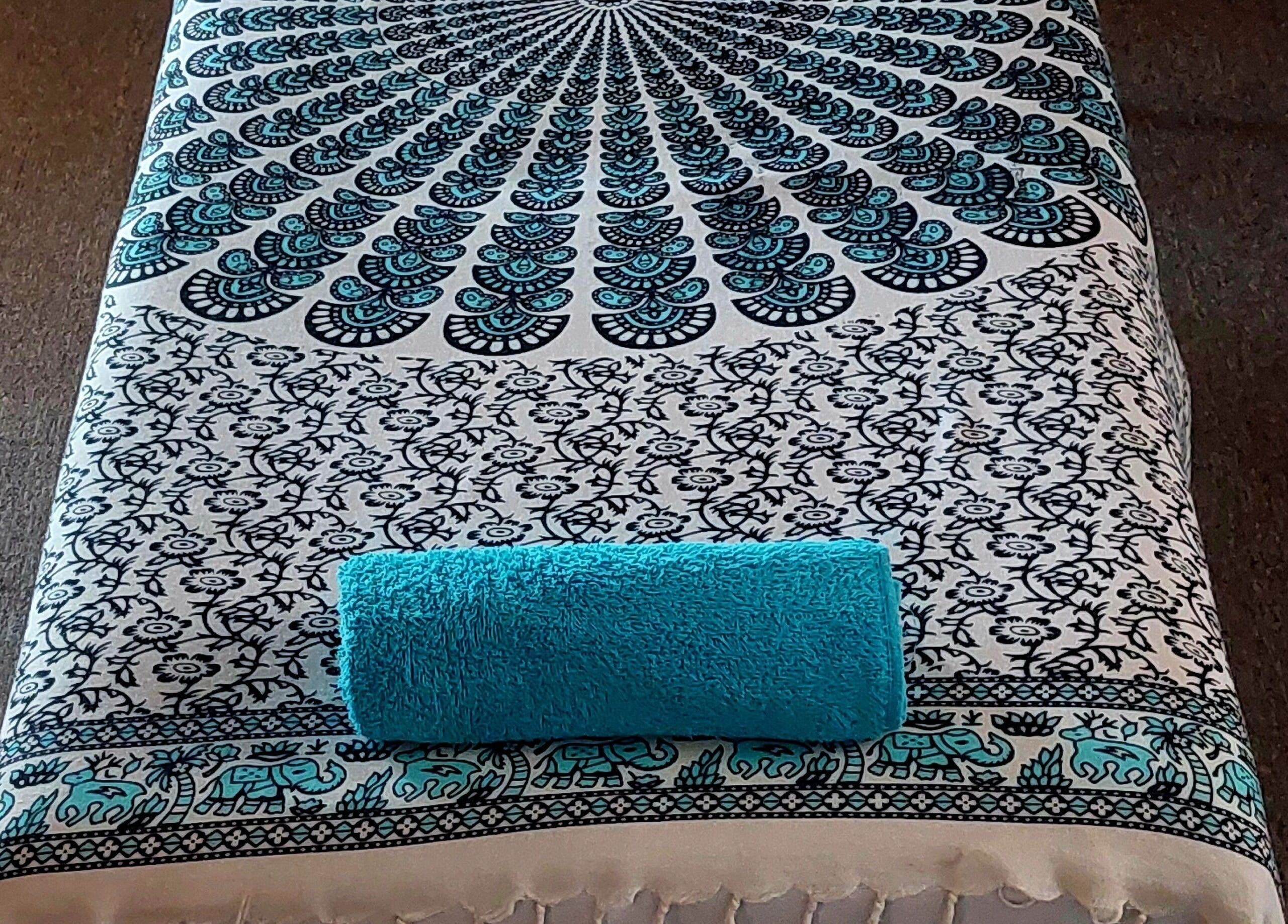 Massage table with a patterned cover and blue towel at LomiLomi Therapeutic Massage, Jeffreys Bay, Eastern Cape, ZA.