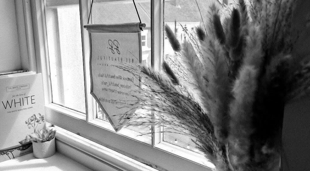 Cozy window decor at Chelsea Louise in Caistor, England, GB featuring pampas grass and books.