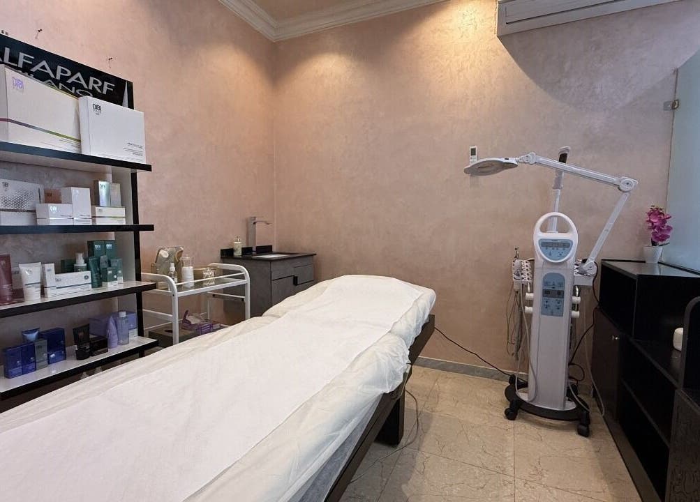 Treatment room at Rouge and Henna Beauty Saloon and Spa, Al Ain, Abu Dhabi, AE with massage bed and skincare products.