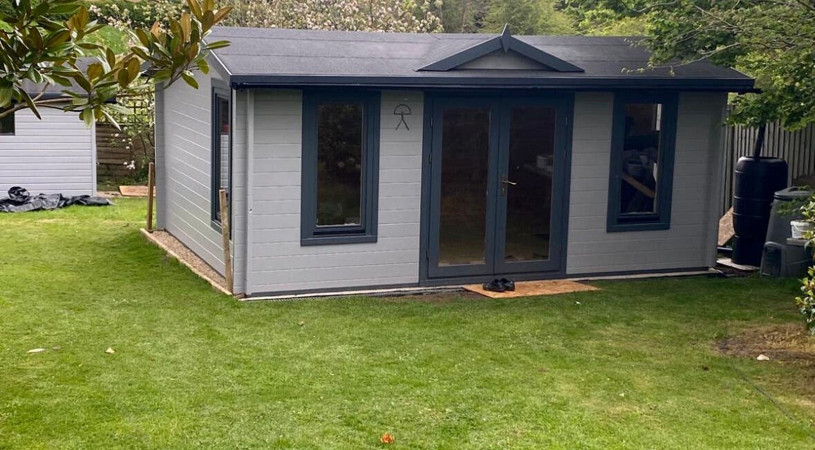 Exterior of Barbering by Teegs' tranquil garden studio in Hawkhurst, England, GB, surrounded by greenery.