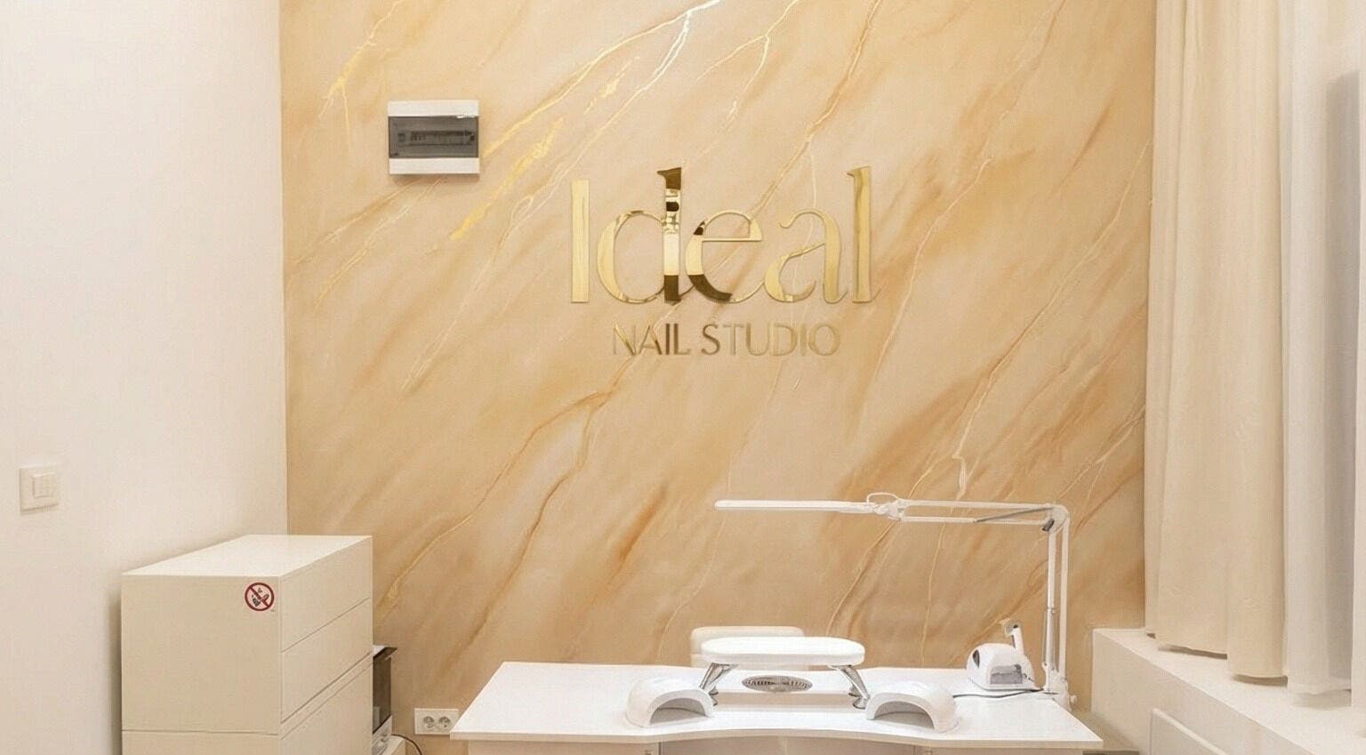 Moderno uređen prostor Ideal Nail Studio, Zagreb, Grad Zagreb, HR s elegantnim zlatnim logotipom na zidu.