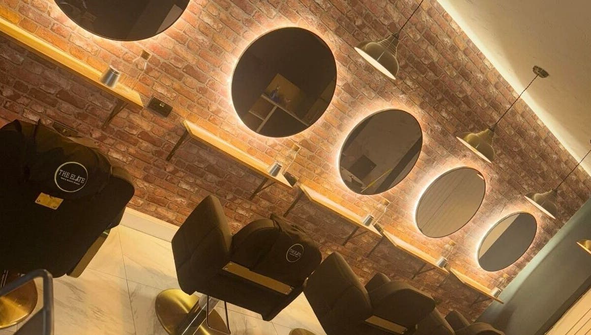 Modern salon interior at Sophie Hair Artist in Thetford, England, GB with illuminated mirrors and styling chairs.