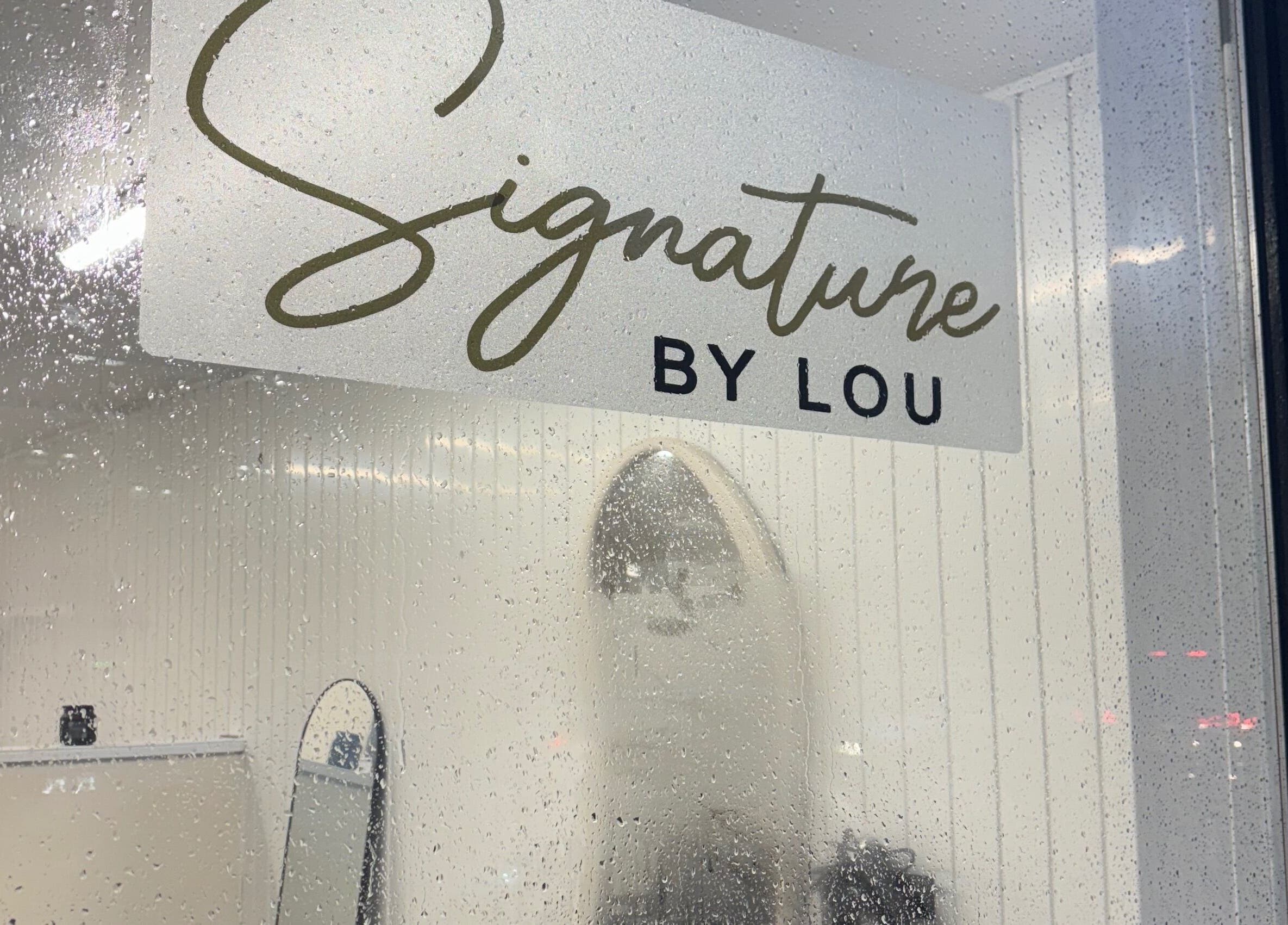 Rain-speckled window at Signature By Lou, Ilkeston, England, GB, showcasing its elegant interior.