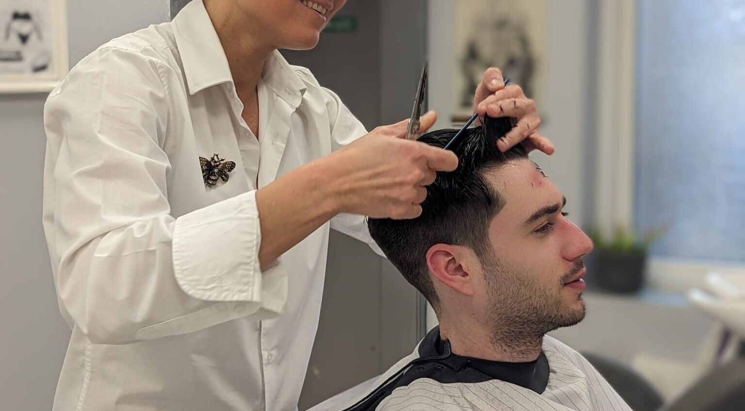 Hairdresser at Mila's head office in Bournemouth, England, GB giving a stylish haircut to a customer.
