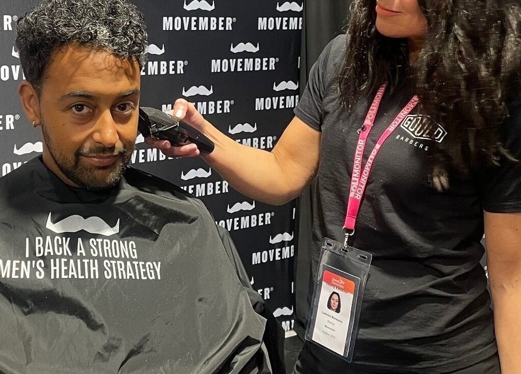 Barber trims hair at event supporting men's health at Mila's head office, Bournemouth, England, GB.