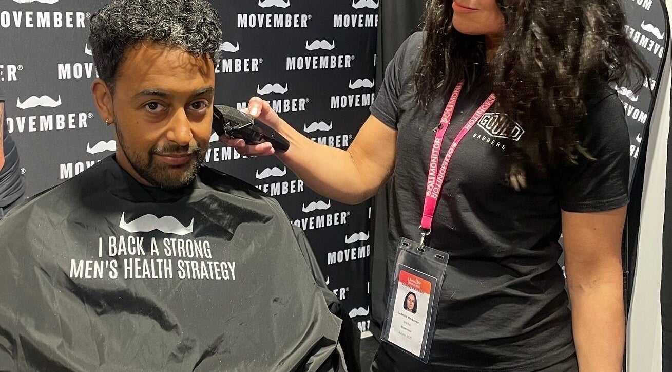 Barber trims hair at event supporting men's health at Mila's head office, Bournemouth, England, GB.