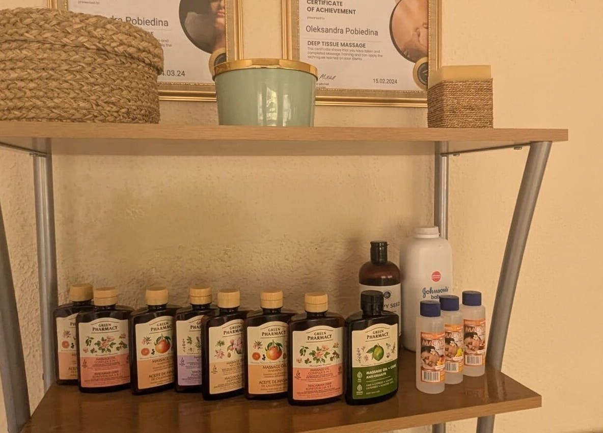 Massage oils and decor on a shelf at Lexa Massage Studio, Keynsham, England, GB for a tranquil ambiance.