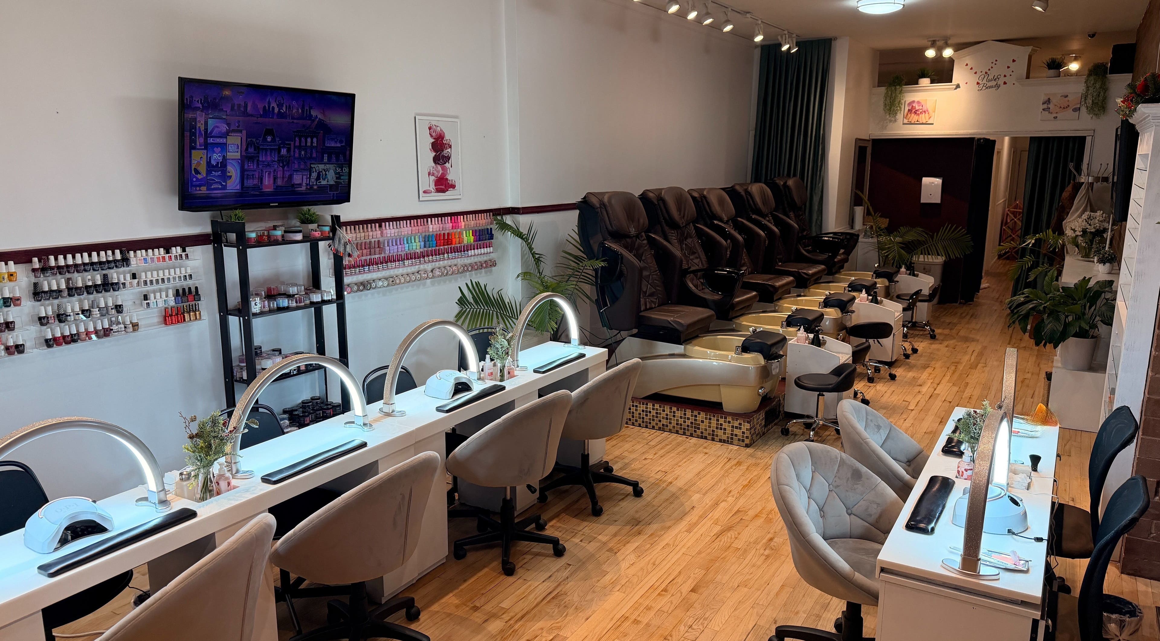 Modern nail salon interior at The Nail Bar on Division in Chicago, Illinois, US with plush seating and polish display.
