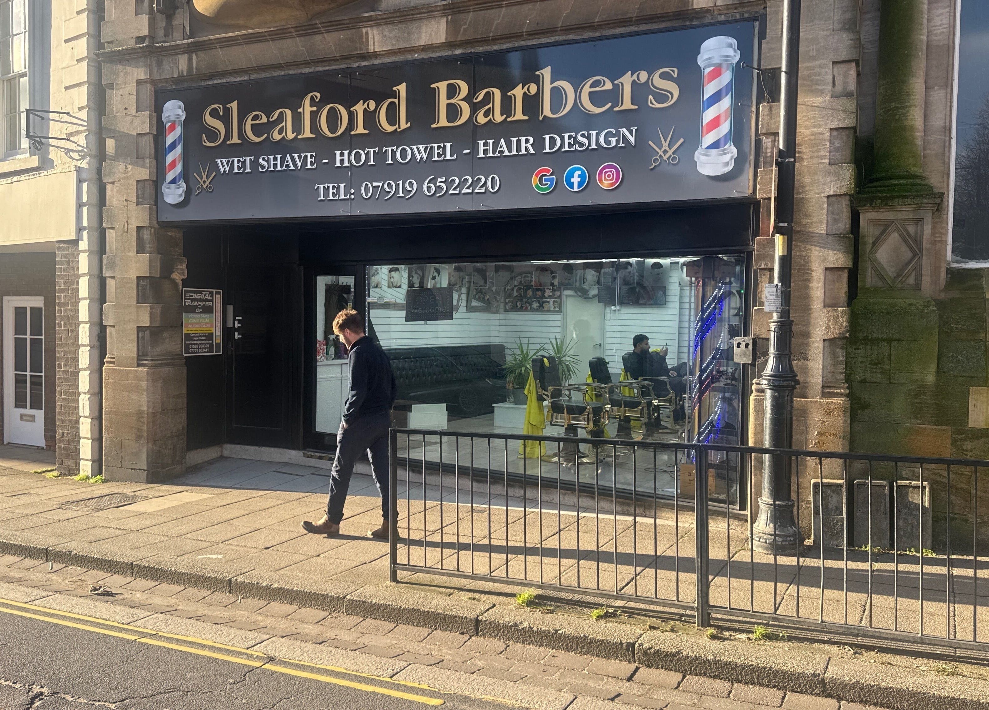 Exterior of Sleaford Barbers in London, England, GB, showcasing the entrance and street view.