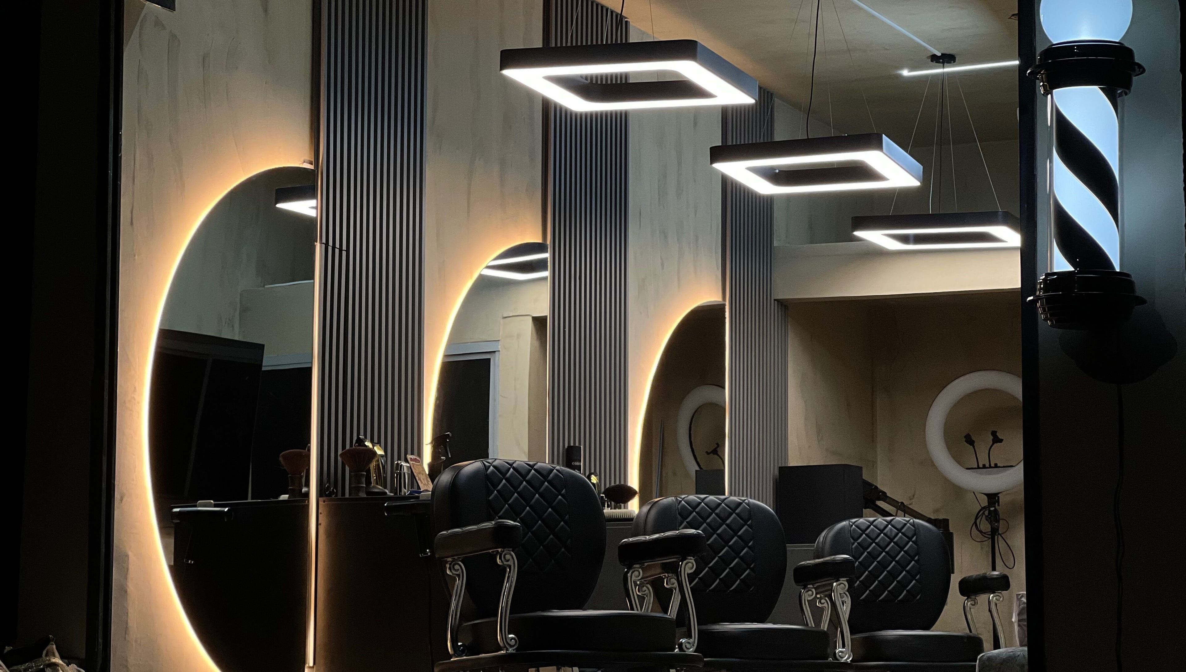 Interior moderno del salón Selecto en Marinilla, CO con sillas negras y luces geométricas.