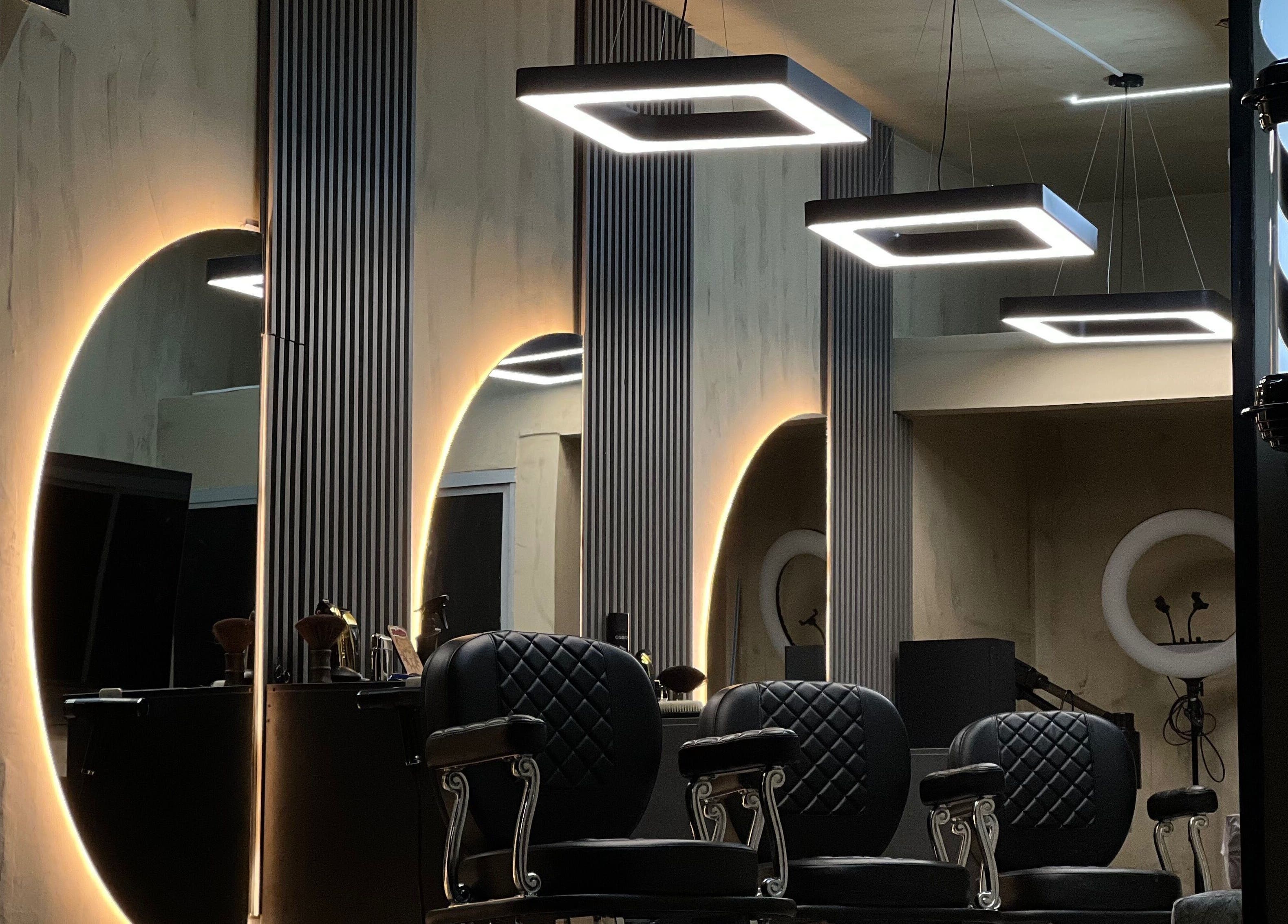 Interior moderno del salón Selecto en Marinilla, CO con sillas negras y luces geométricas.