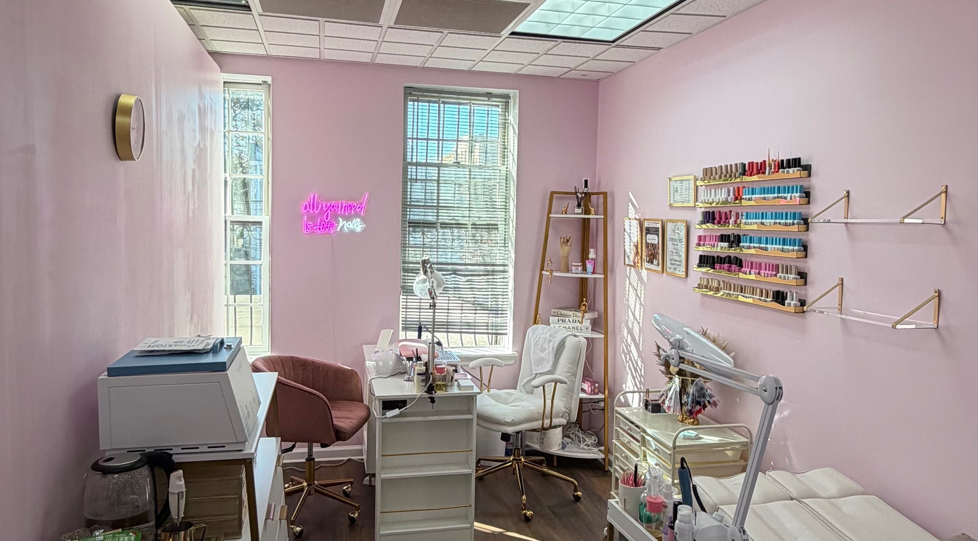 Сучасний салон HerynNails у Нью-Йорку з рожевими стінами, робочими місцями та полицями з лаком.