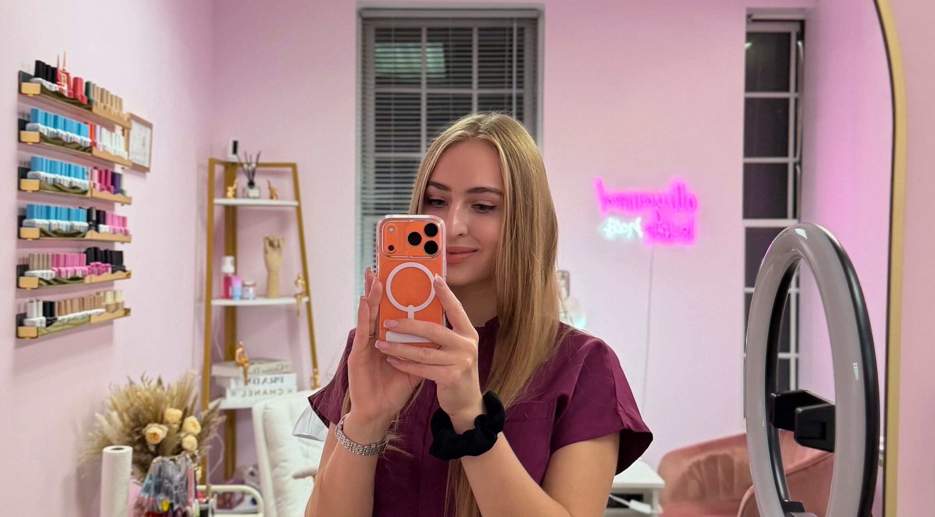 Салон HerynNails у New York, New York, US, з прикрасами та манікюрними лаками, жінка робить селфі.