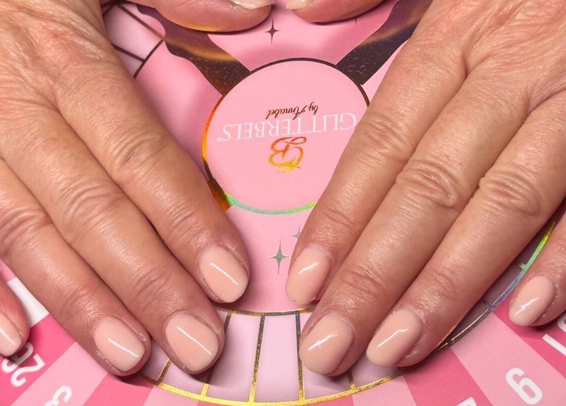 Manicured hands showcasing elegant blush nails at Nail Design by Ellie, Luton, England, GB.