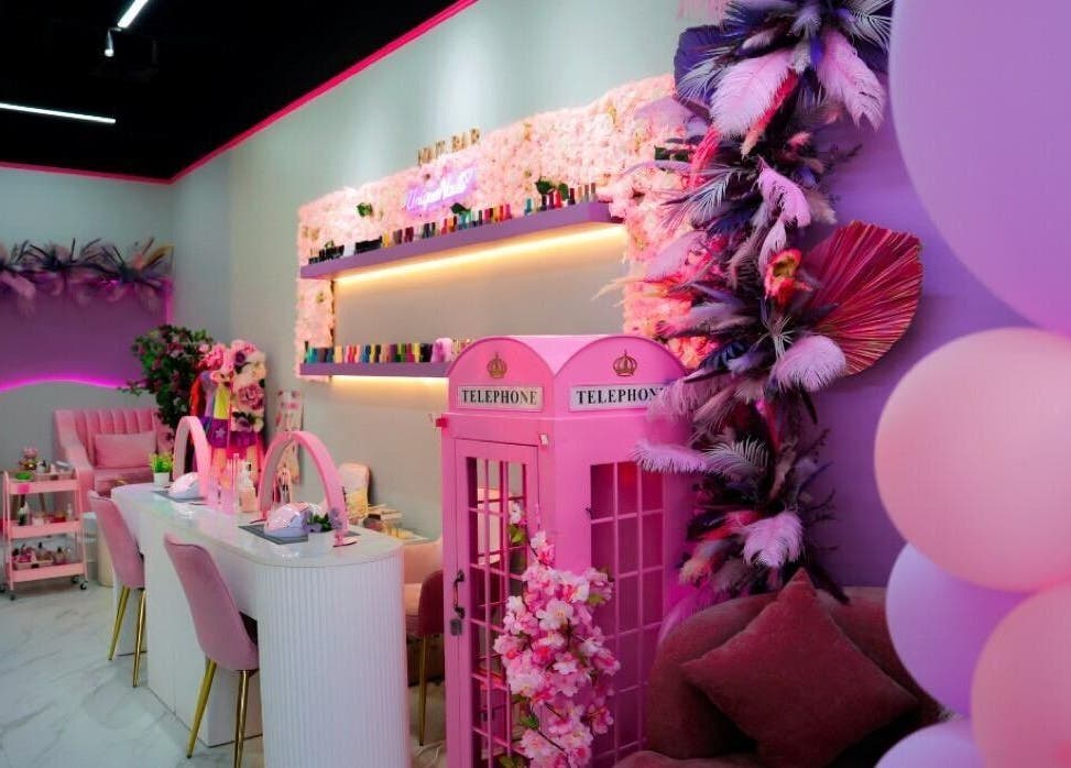Chic interior of Unique Station Beauty Salon in Dubai, AE, featuring vibrant pink decor and elegant seating.