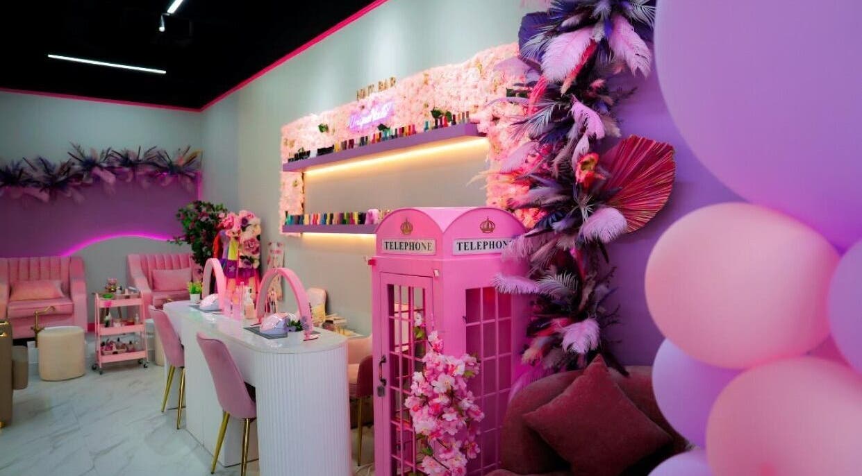 Chic interior of Unique Station Beauty Salon in Dubai, AE, featuring vibrant pink decor and elegant seating.