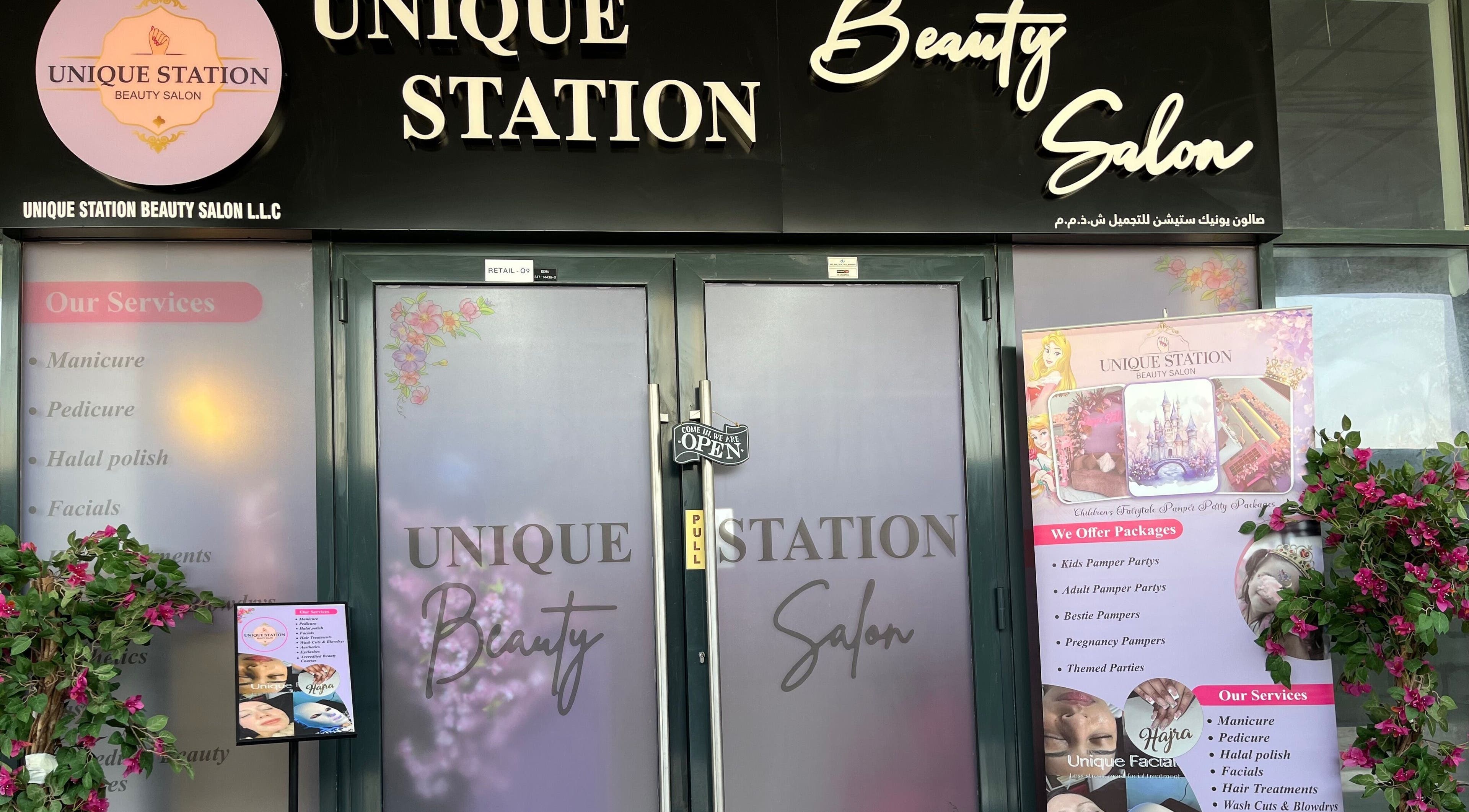 Front view of Unique Station Beauty Salon in Dubai, AE featuring services menu and welcoming decor.
