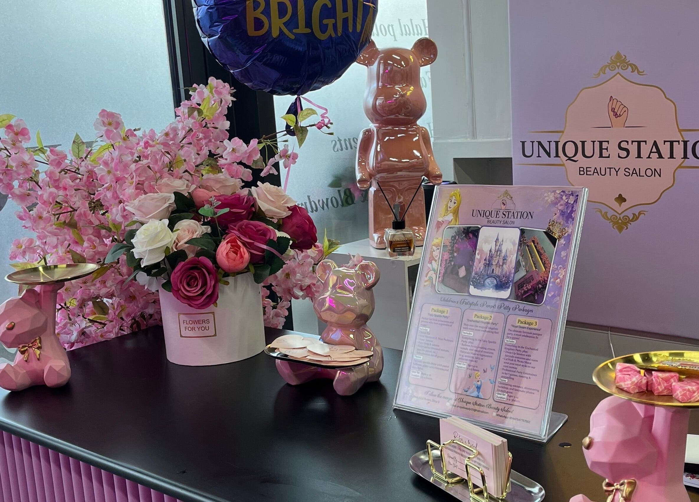 Chic front desk at Unique Station Beauty Salon with floral decor, Dubai, AE showcasing services.