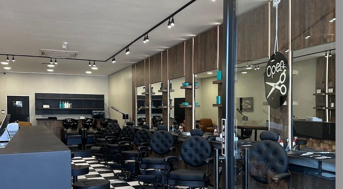 Interior view of The Dapper Don in Sandton, Gauteng, ZA. Stylish barber chairs and mirrors line the chic salon.