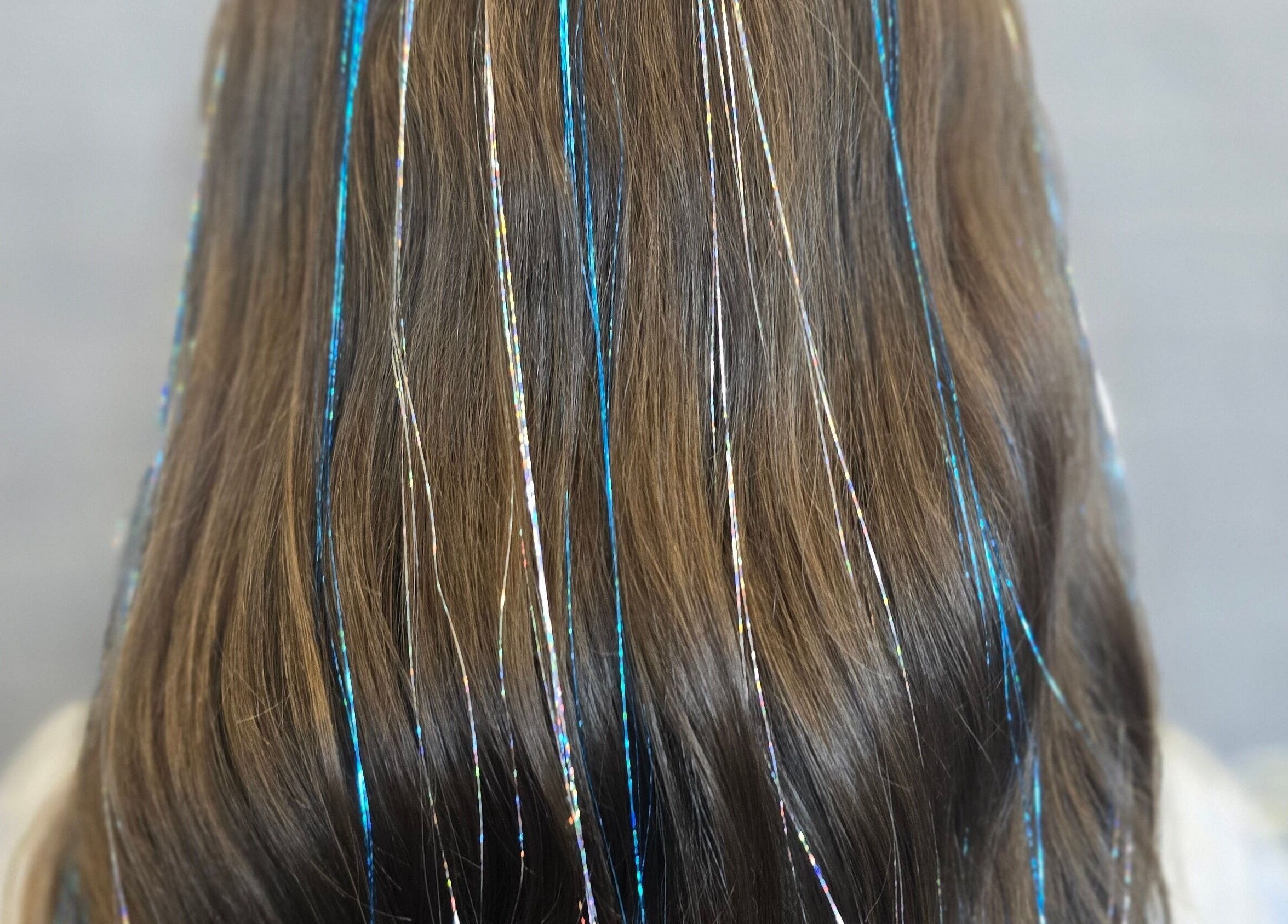 Long brown hair with shimmering tinsel highlights at Stephs Styles, Johnstone, Scotland, GB.
