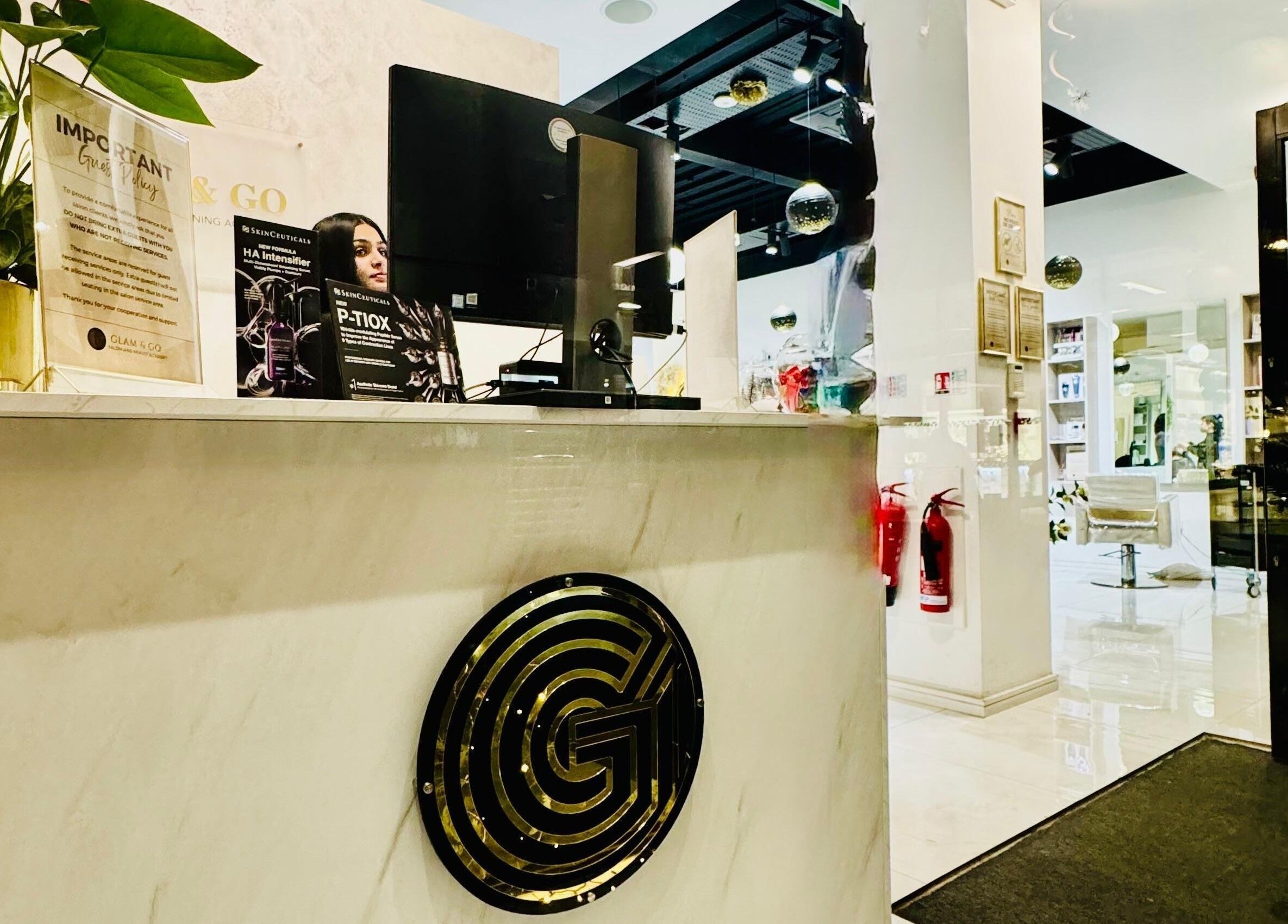 Reception area at Glam & Go Hounslow in Hounslow, England, GB, featuring a sleek marble desk and modern decor.