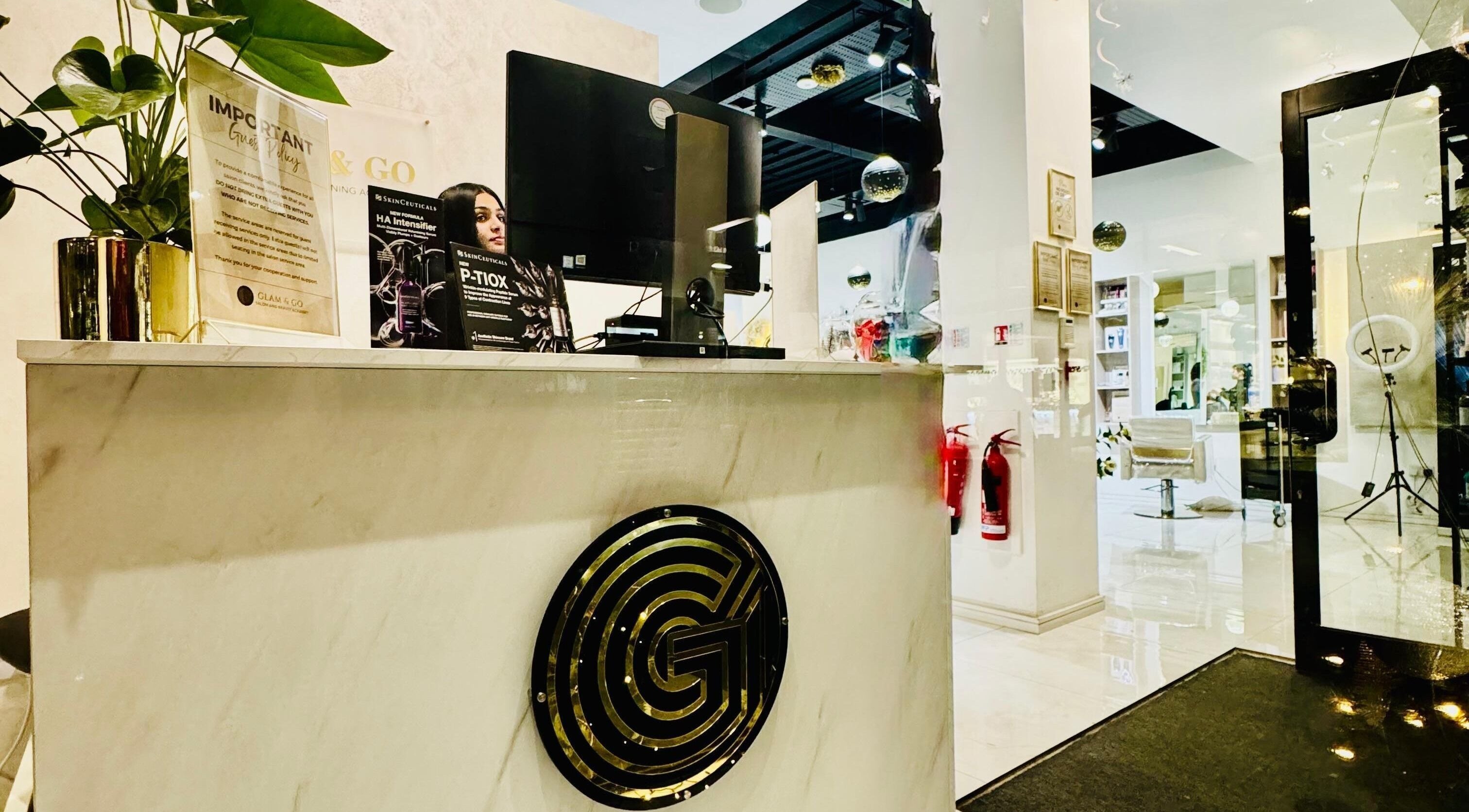 Reception area at Glam & Go Hounslow in Hounslow, England, GB, featuring a sleek marble desk and modern decor.