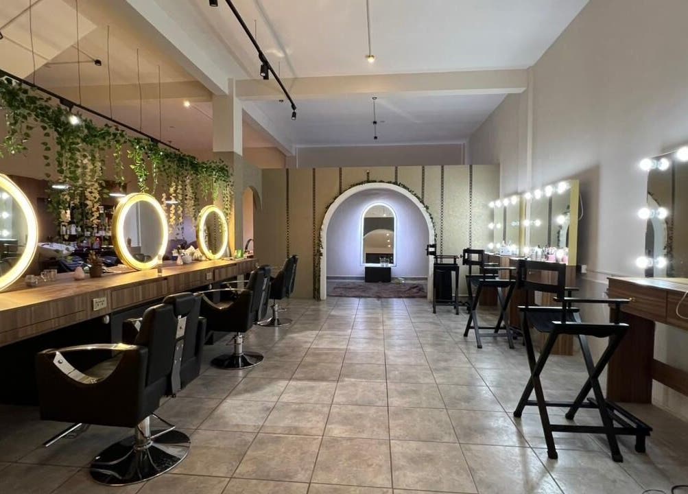Espace élégant chez Clau Beauty Studio à Cochabamba, avec miroirs illuminés et chaises de coiffure.