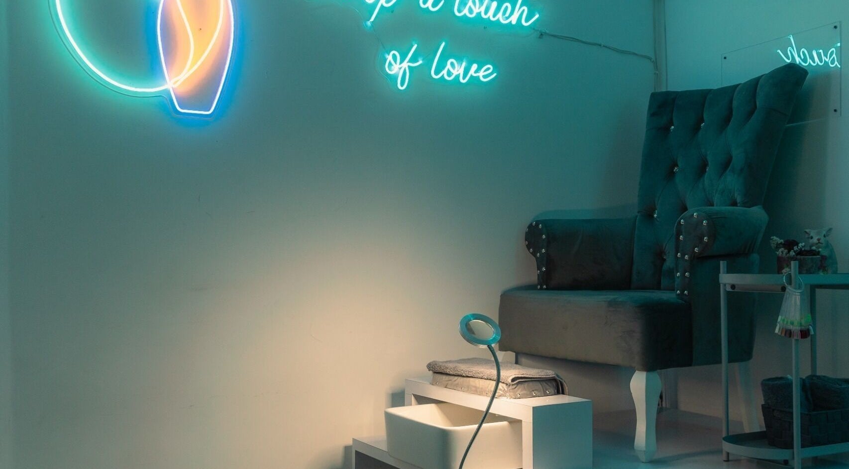 Espacio acogedor en Gotita Studio, Ciudad De México, con silla de terciopelo y luces de neón.