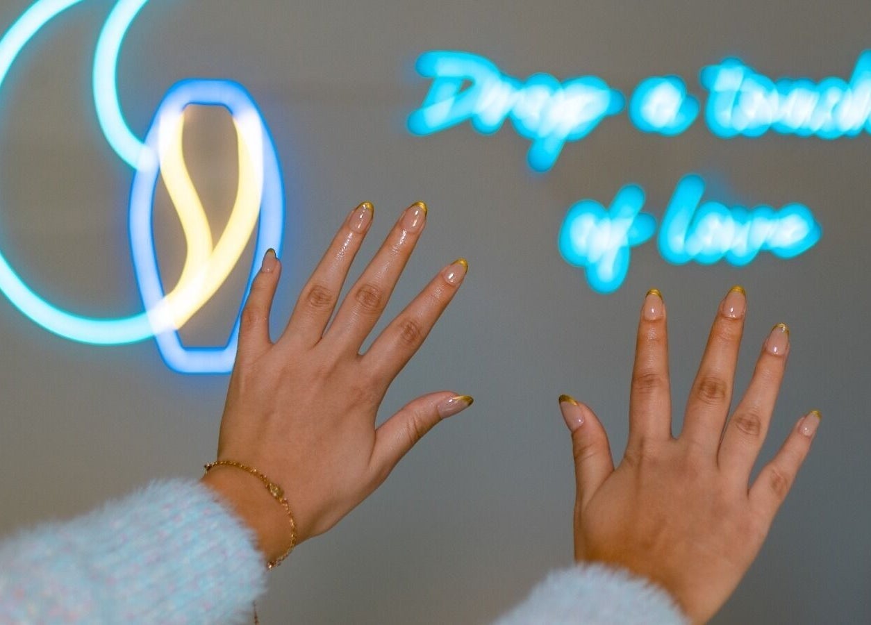 Uñas con manicura brillante en Gotita Nails, Ciudad De México, Ciudad De México, MX con fondo neón.