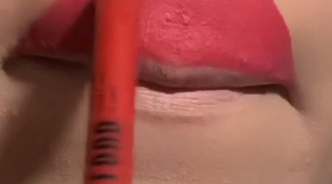 Applying pink lip color at Glowbit, Abuja, Federal Capital Territory, NG for a fresh look.