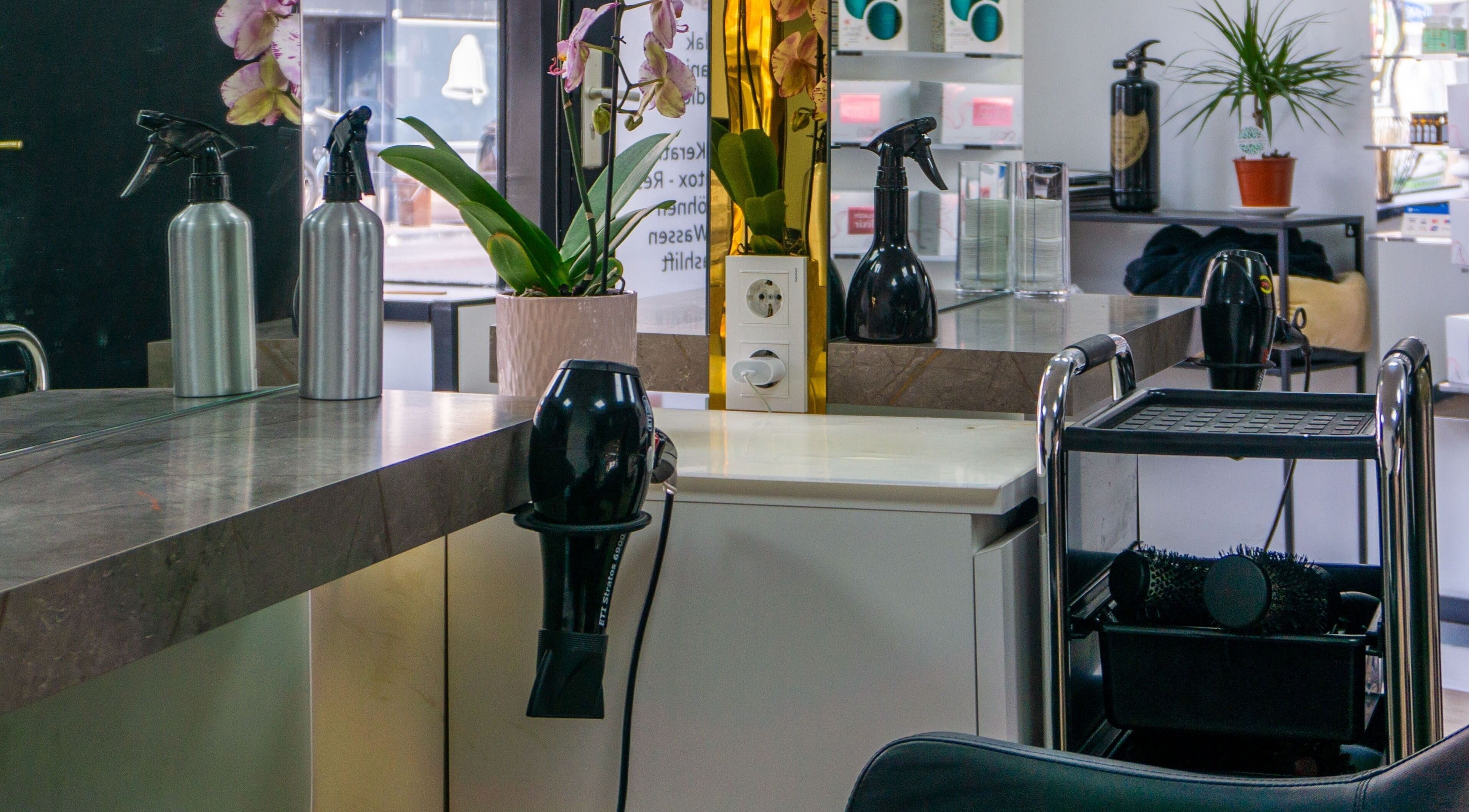 Sleek salon interior at Metamorfosa, featuring stylish equipment and greenery in Utrecht, NL.