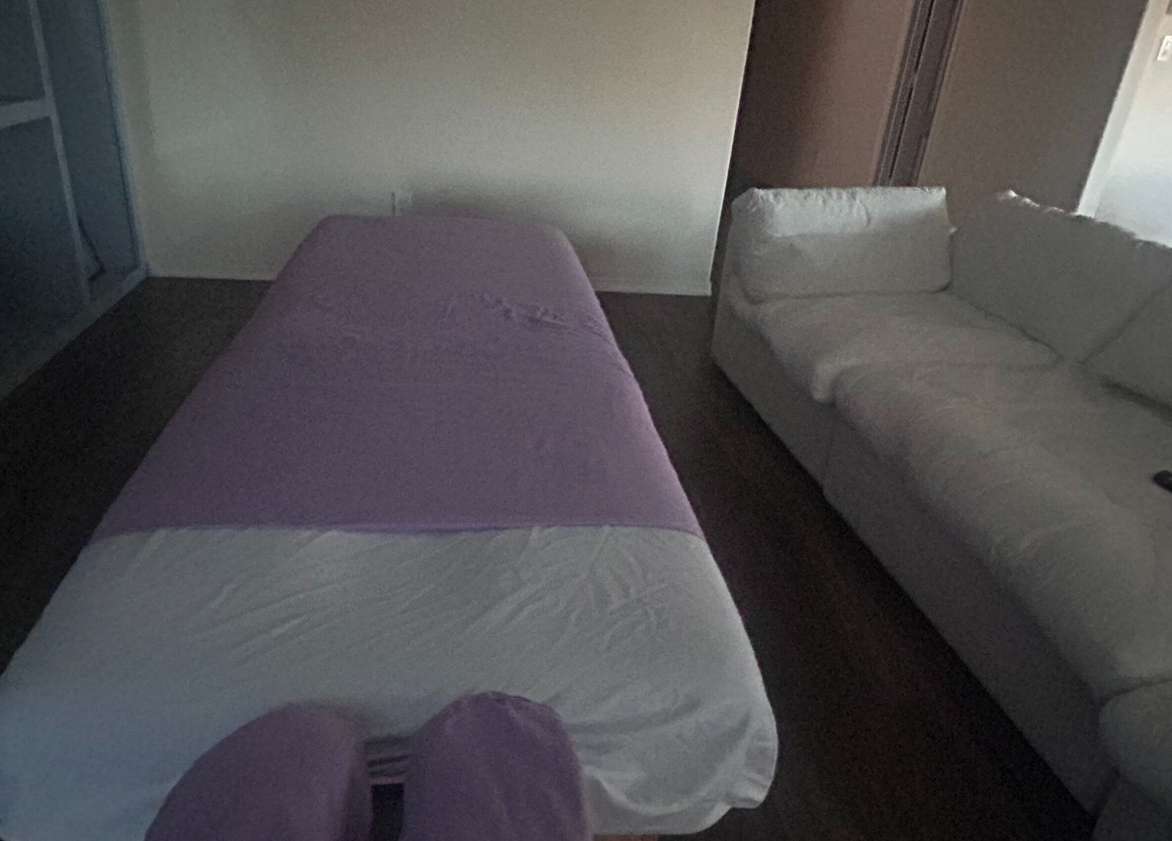 A peaceful massage setup at Mindful Motion Mobile Massage, US, featuring a massage table and cozy sofa.