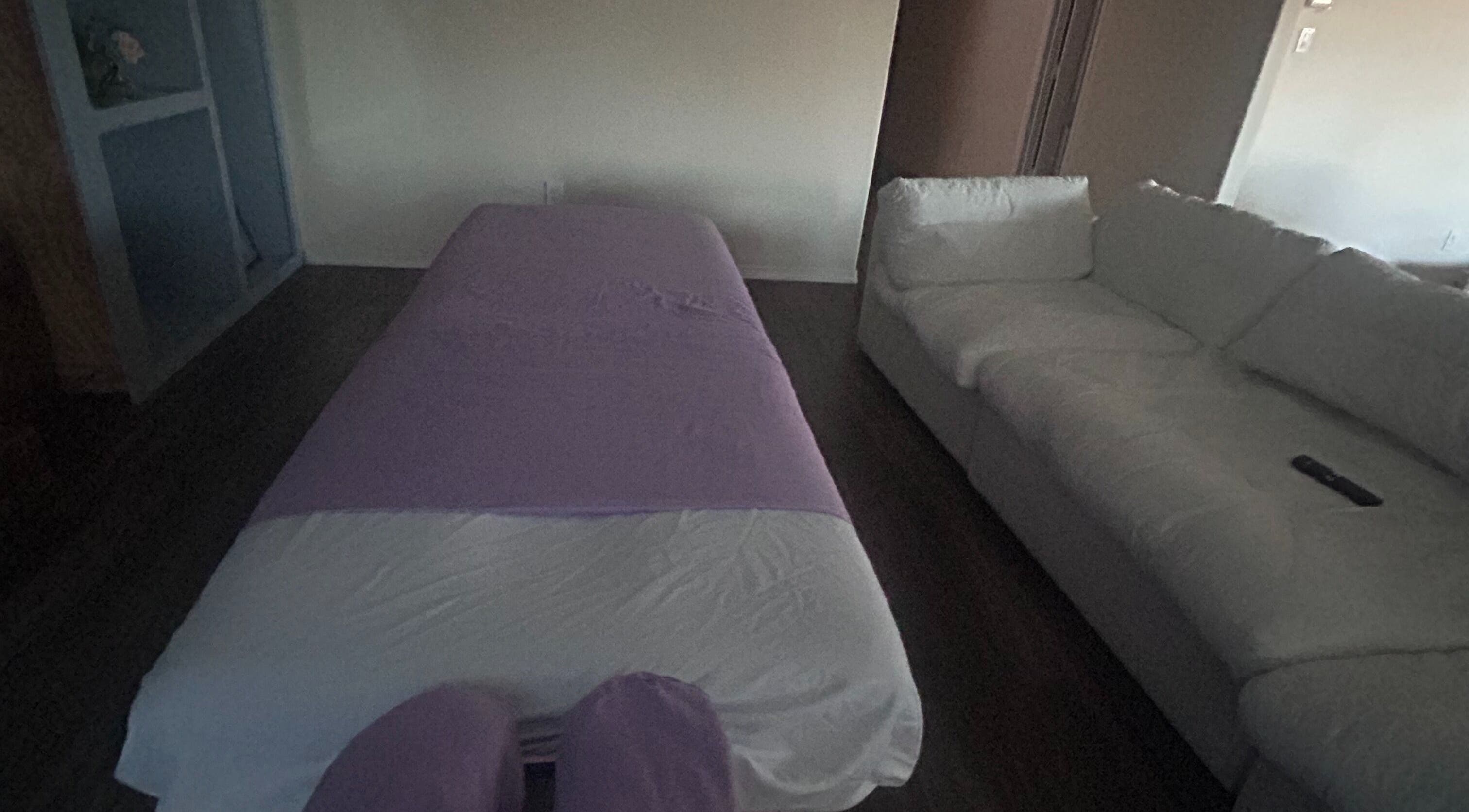 A peaceful massage setup at Mindful Motion Mobile Massage, US, featuring a massage table and cozy sofa.