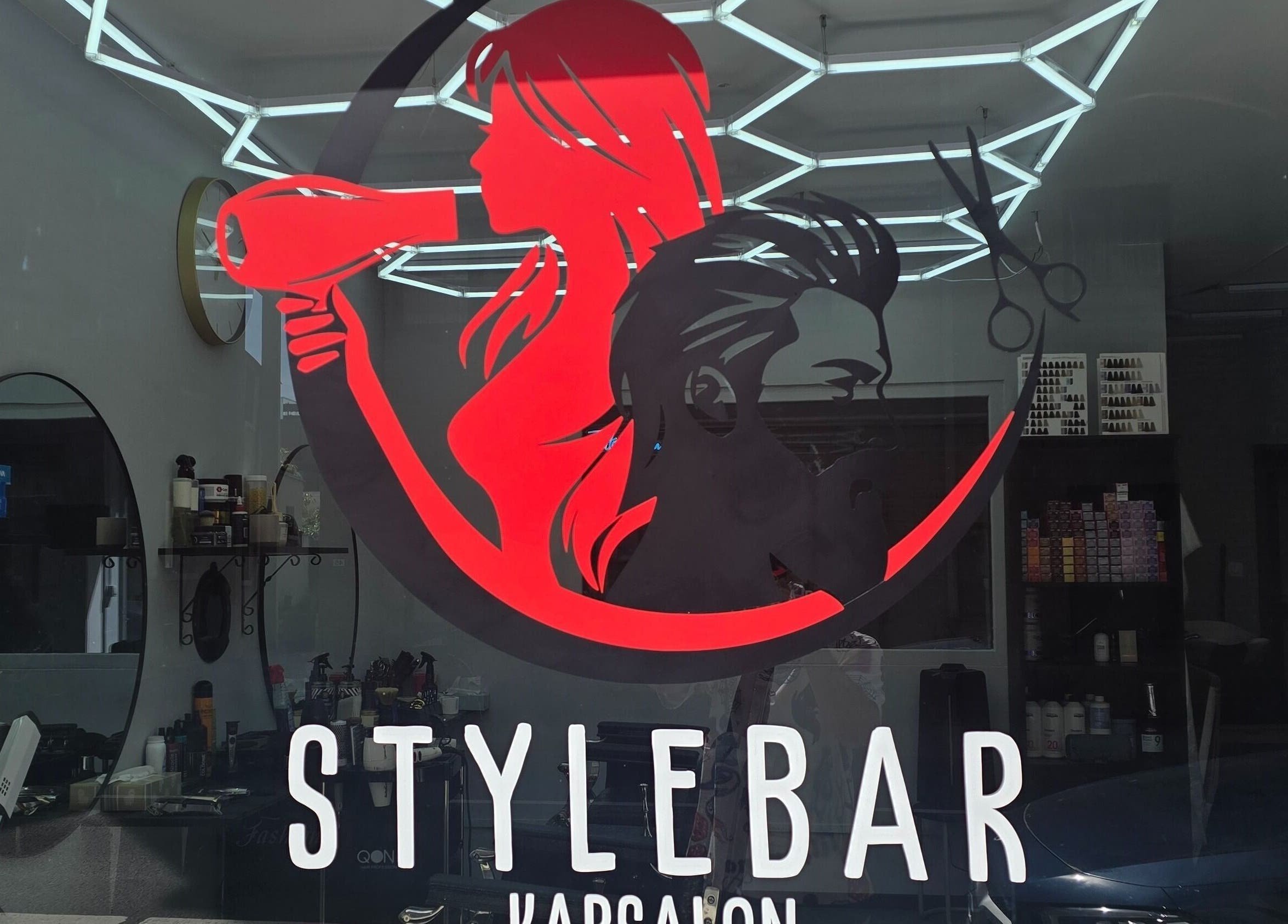 Moderne gevel van Stylebar Kapsalon Leuven in Vlaanderen, BE met opvallend logo en kapsalon interieur.