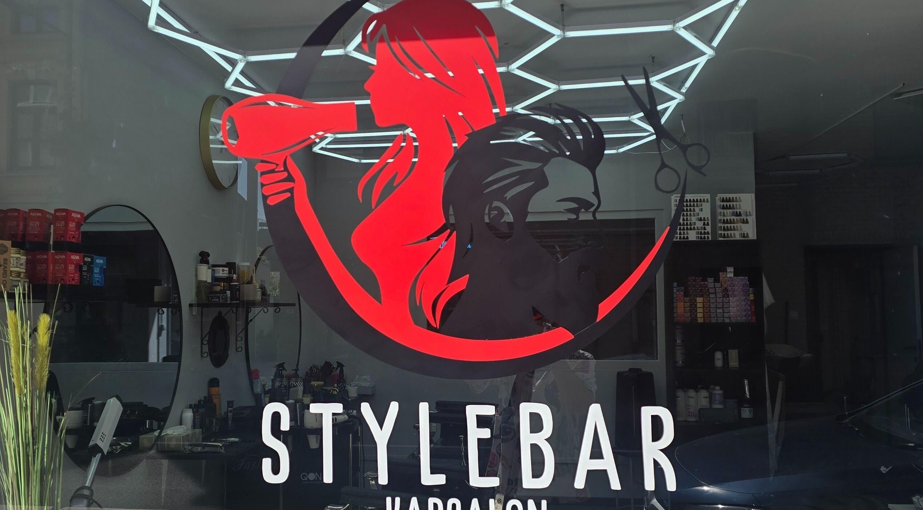 Moderne gevel van Stylebar Kapsalon Leuven in Vlaanderen, BE met opvallend logo en kapsalon interieur.