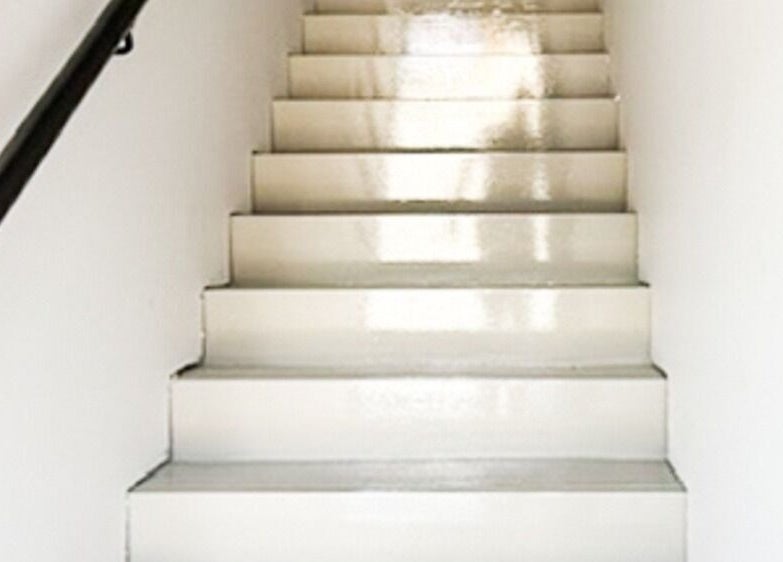 Staircase leading to CR Aesthetics at Drouin, Victoria, AU. Features glossy white steps and a black railing.