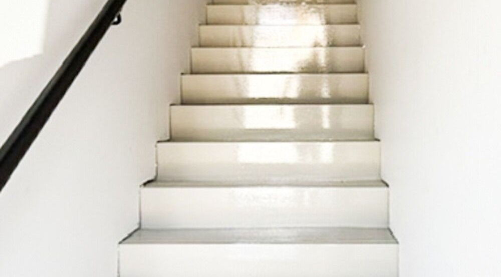 Staircase leading to CR Aesthetics at Drouin, Victoria, AU. Features glossy white steps and a black railing.