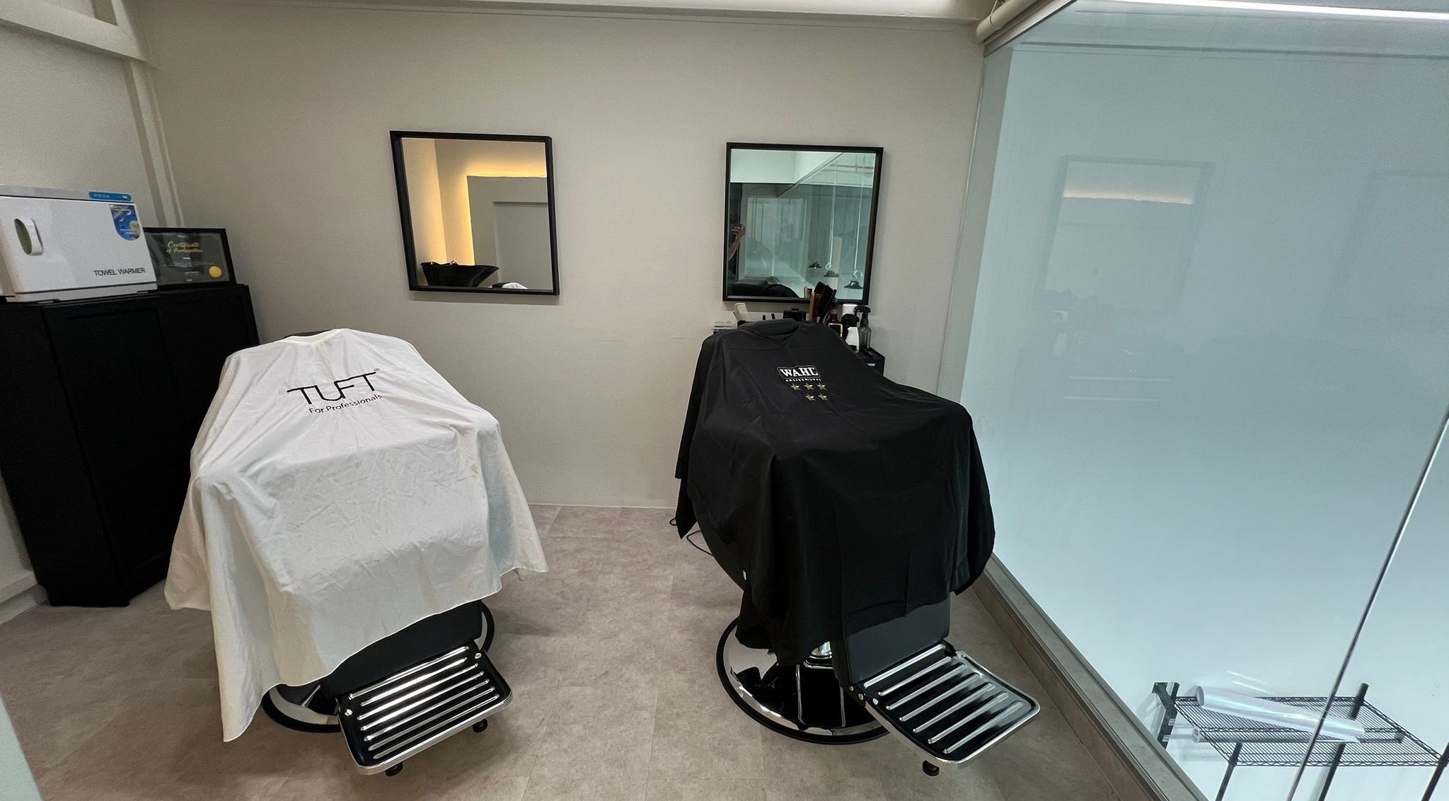 Modern barber chairs at Tino The Barber Shop, Singapore, SG, in a sleek, minimalist setup.