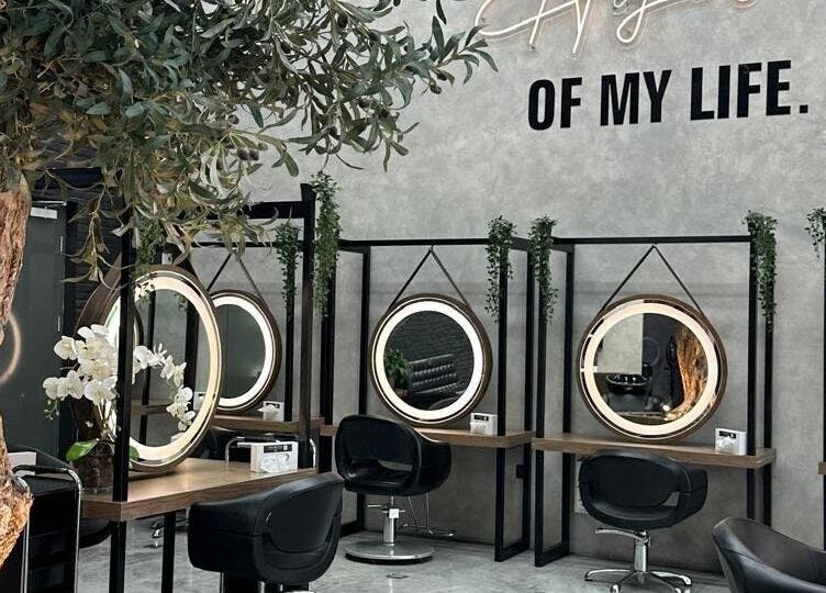 داخل صالون Brazil Studio Salon - Khobar في الخبر، يتميز بمرايا مستديرة وتصميم داخلي جذاب.