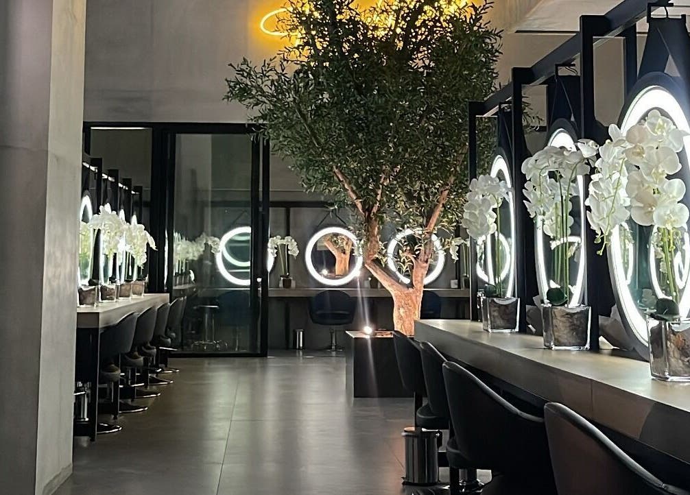 تصميم داخلي أنيق في Brazil Studio Salon - Riyadh، الرياض، منطقة الرياض، السعودية، مع مرايا مستديرة وزهور.