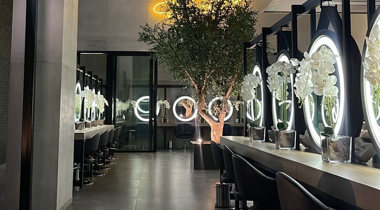 تصميم داخلي أنيق في Brazil Studio Salon - Riyadh، الرياض، منطقة الرياض، السعودية، مع مرايا مستديرة وزهور.