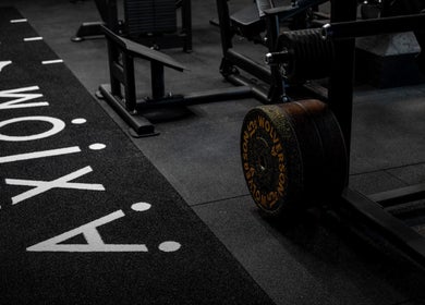 Gym floor at AXIOM PT Studio, London, England, GB, featuring weights and equipment.