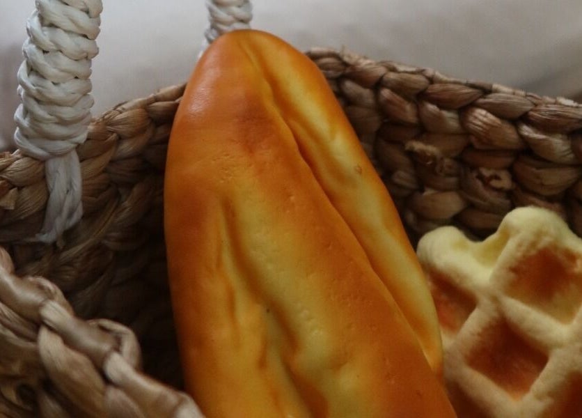 Fresh baguette and waffle in a woven basket at Booty Bakery, Bali, Bali, ID.