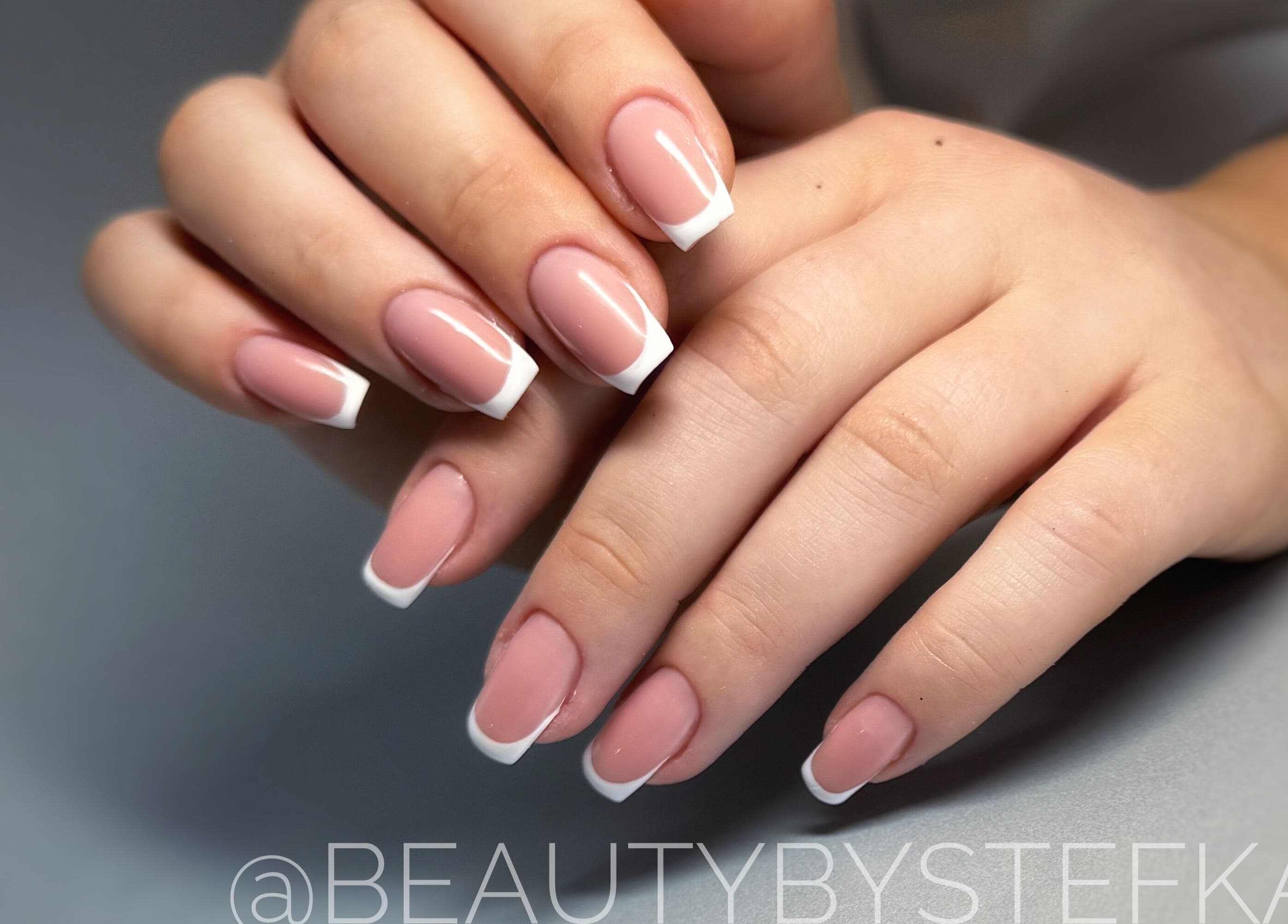 Elegant French manicure at SKA.NAILS in Norwich, England, GB, showcasing glossy nude and white nail art.