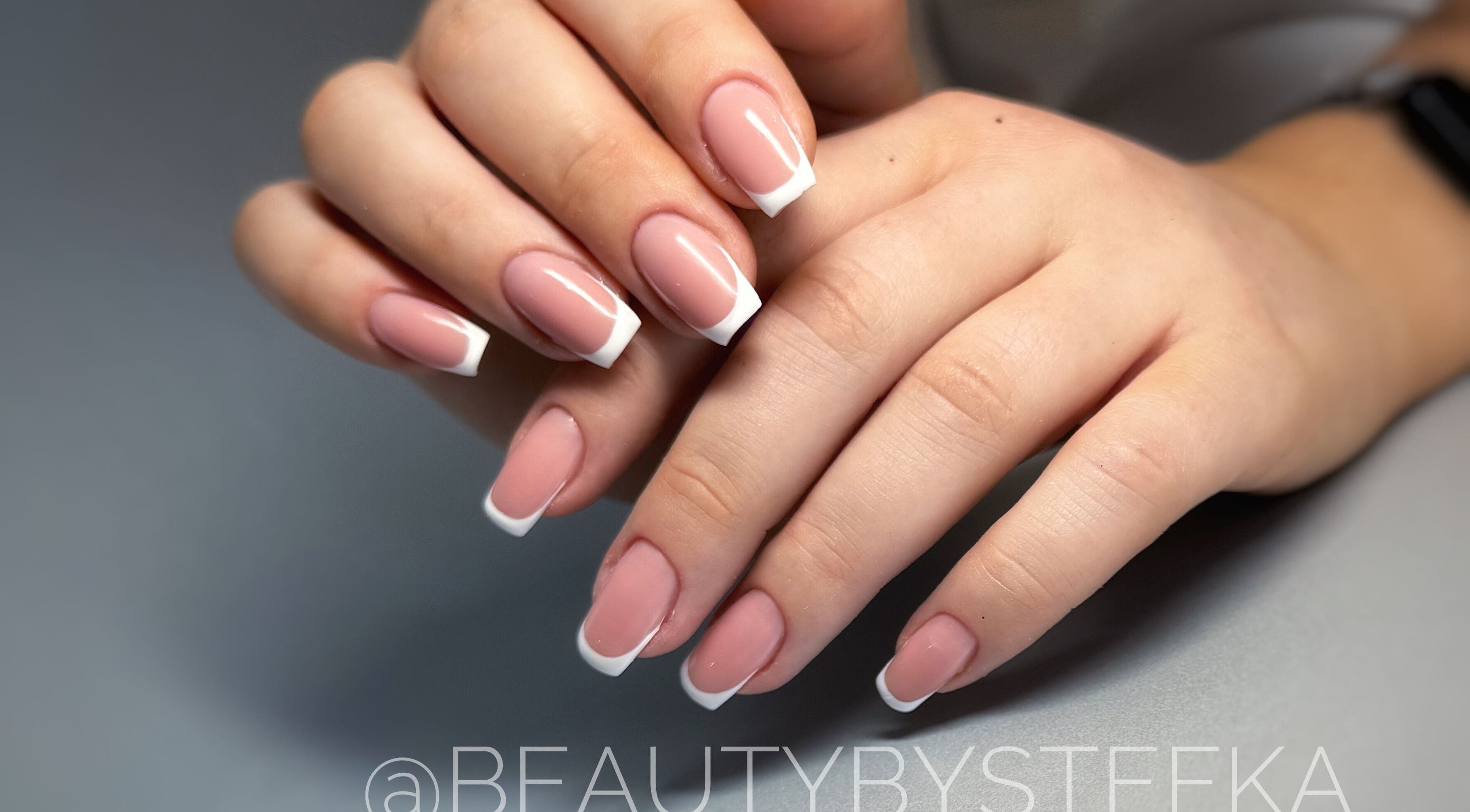 Elegant French manicure at SKA.NAILS in Norwich, England, GB, showcasing glossy nude and white nail art.
