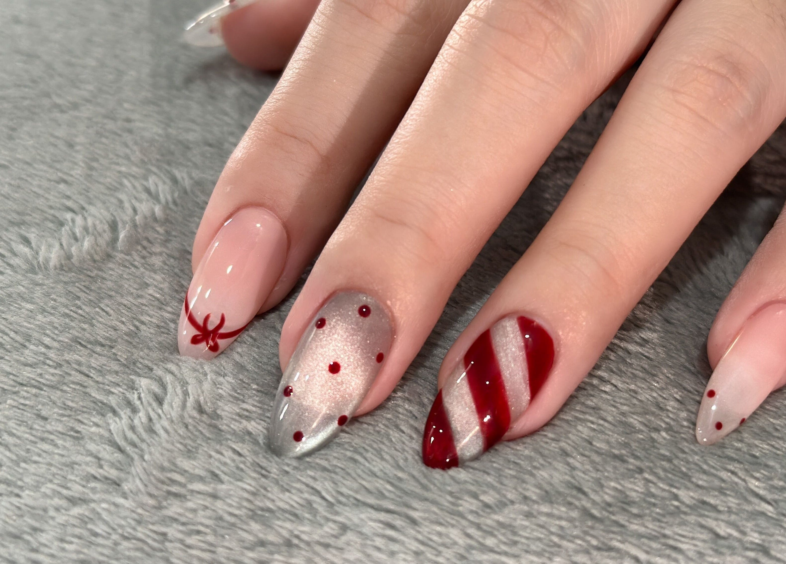 Festive nail art with red patterns at GOLDFINCH NAILS STUDIO in Haslemere, England, GB.