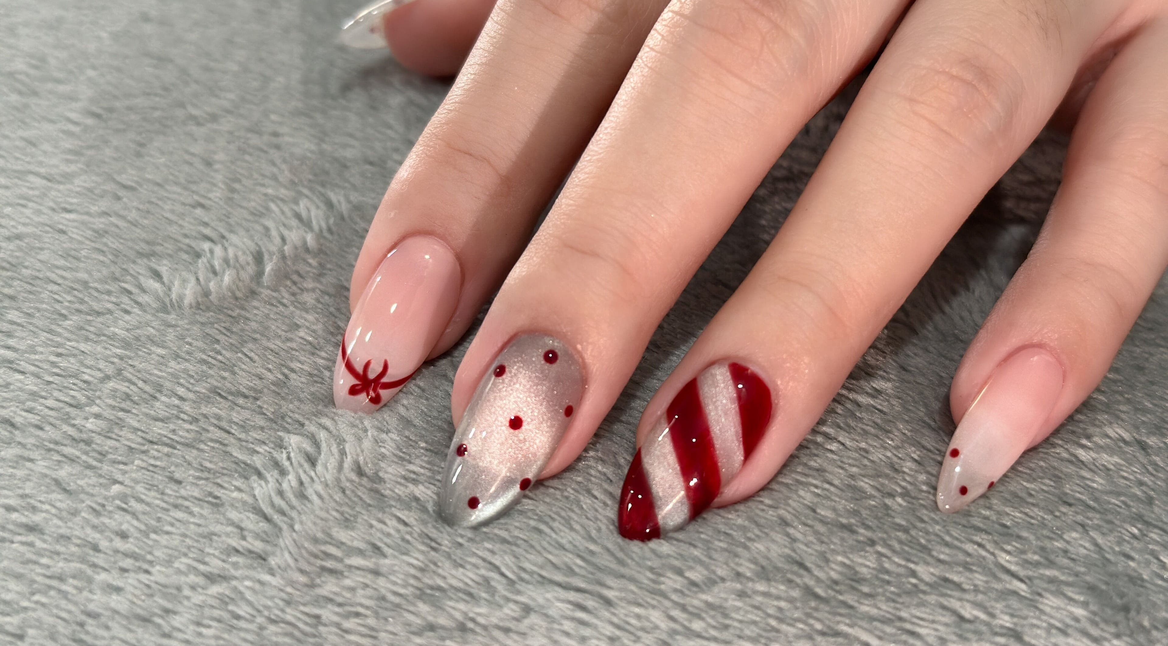 Festive nail art with red patterns at GOLDFINCH NAILS STUDIO in Haslemere, England, GB.